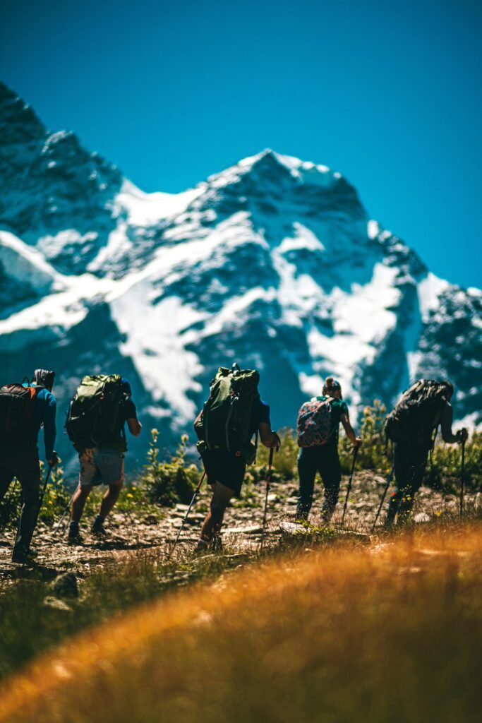 pexels-photo-5151296-5151296 A group of hikers trekking on a sunny day by snowy mountains, showcasing adventure and exploration.